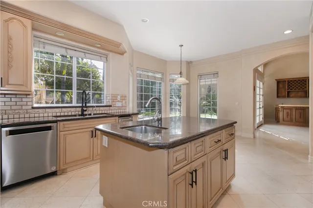 a kitchen with stainless steel appliances granite countertop a sink and a large window