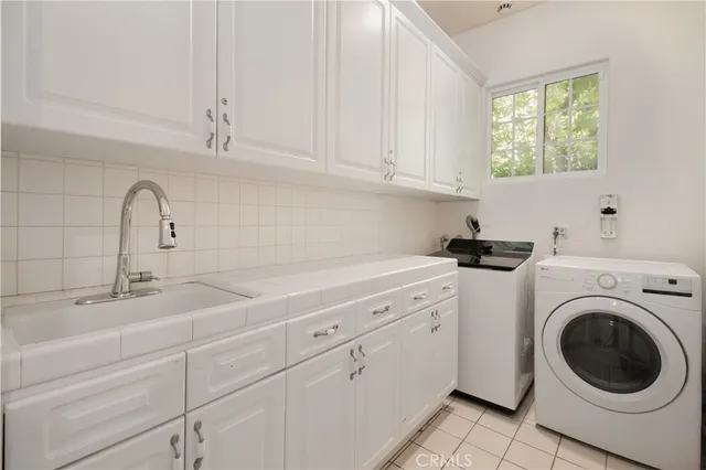 a kitchen with white cabinets and sink