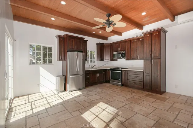 a kitchen with stainless steel appliances kitchen island granite countertop a refrigerator and a sink
