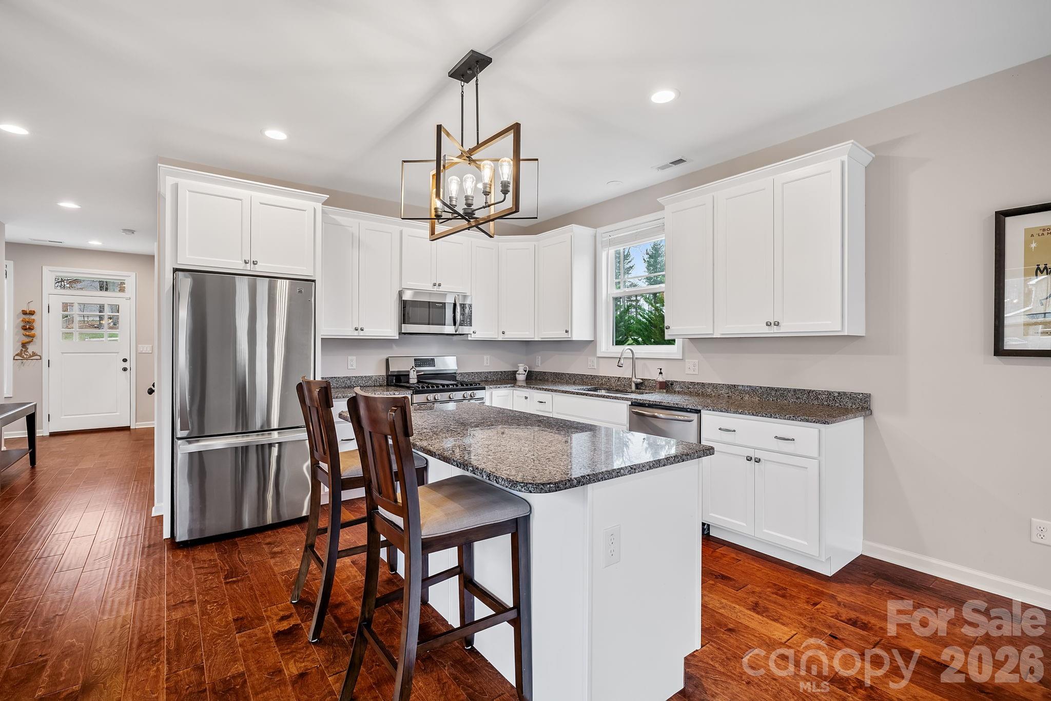 57 Parrot Road Candler, NC 28715 - Photo 11 of 44 a kitchen with stainless steel appliances granite countertop a dining table chairs refrigerator and microwave