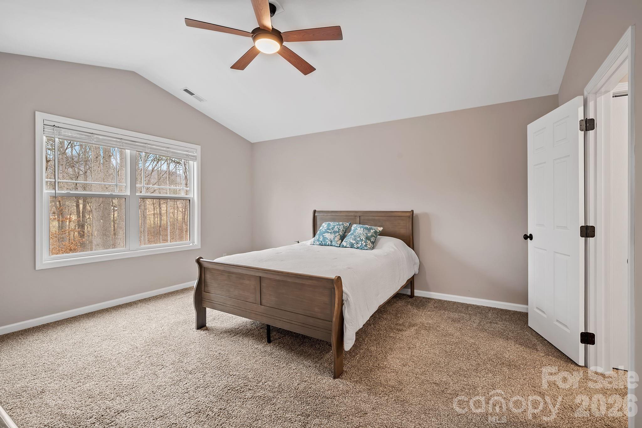 57 Parrot Road Candler, NC 28715 - Photo 19 of 44 a spacious bedroom with a bed and a window
