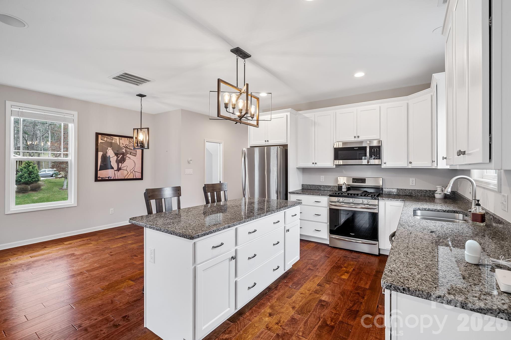 57 Parrot Road Candler, NC 28715 - Photo 9 of 44 a kitchen with stainless steel appliances granite countertop a sink refrigerator stove and microwave
