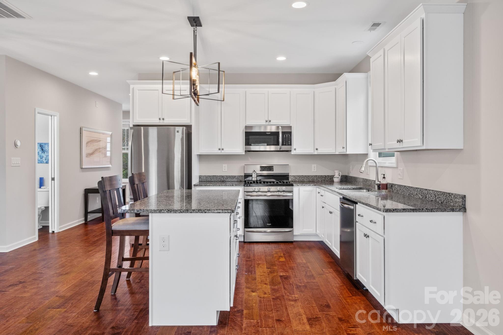 57 Parrot Road Candler, NC 28715 - Photo 10 of 44 a kitchen with stainless steel appliances a refrigerator a stove a sink dishwasher and a refrigerator with wooden floor