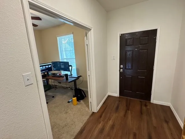 a view of a hallway and a livingroom with furniture