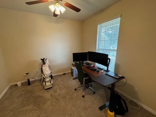 a view of a workspace with furniture and a window