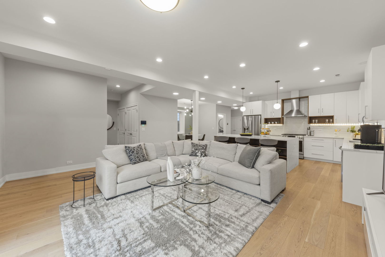 1126 Pitner Avenue Evanston, IL 60202 - Photo 10 of 48 a living room with white couches and kitchen view with wooden floor