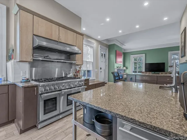 a kitchen with stainless steel appliances granite countertop a stove a sink and a microwave