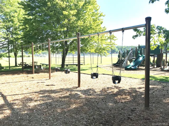 a front view of a building with a garden and trees