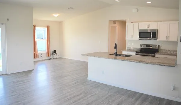a kitchen with stainless steel appliances granite countertop a sink a microwave counter space and wooden floor