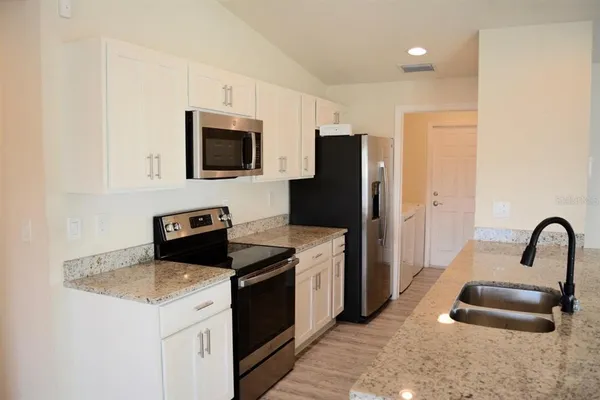 a kitchen with a refrigerator stove and sink