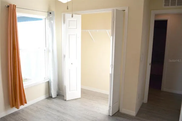 a view of an empty room with wooden floor