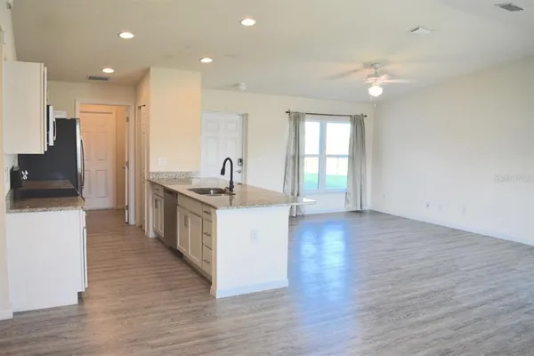 a kitchen with stainless steel appliances granite countertop a sink and a refrigerator