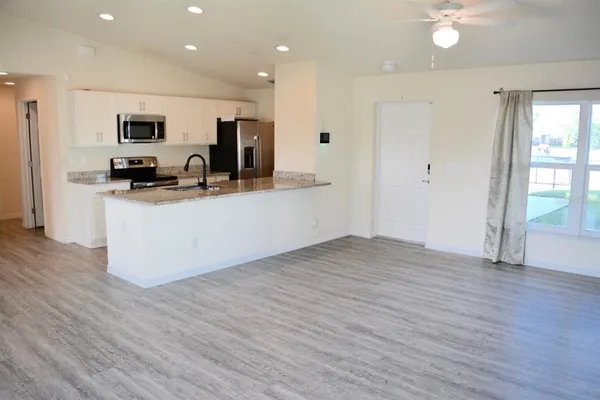 a kitchen with stainless steel appliances a refrigerator and a stove top oven
