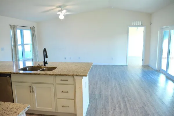 a kitchen with a sink cabinets and wooden floor