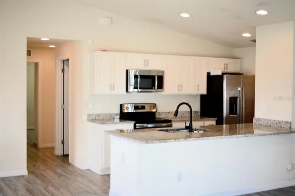 a kitchen with stainless steel appliances granite countertop a sink and a refrigerator