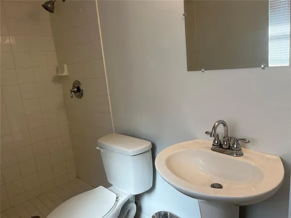 a bathroom with a sink a toilet and a mirror