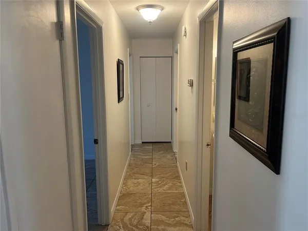 a view of a hallway with wooden floor and a bathroom