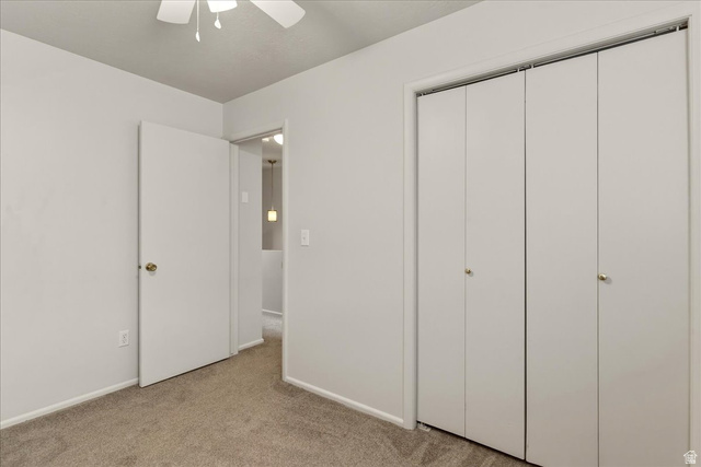 947 Canyon Road, Unit 29 Ogden, UT 84404 - Photo 15 of 19 Unfurnished bedroom with light colored carpet, a closet, and ceiling fan