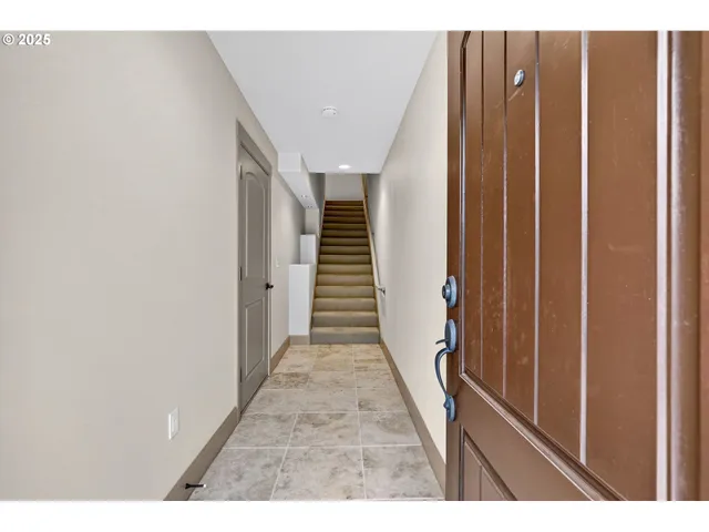 a view of an empty room with wooden floor fireplace and a window