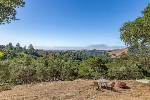 a view of a backyard with wooden fence and a bench