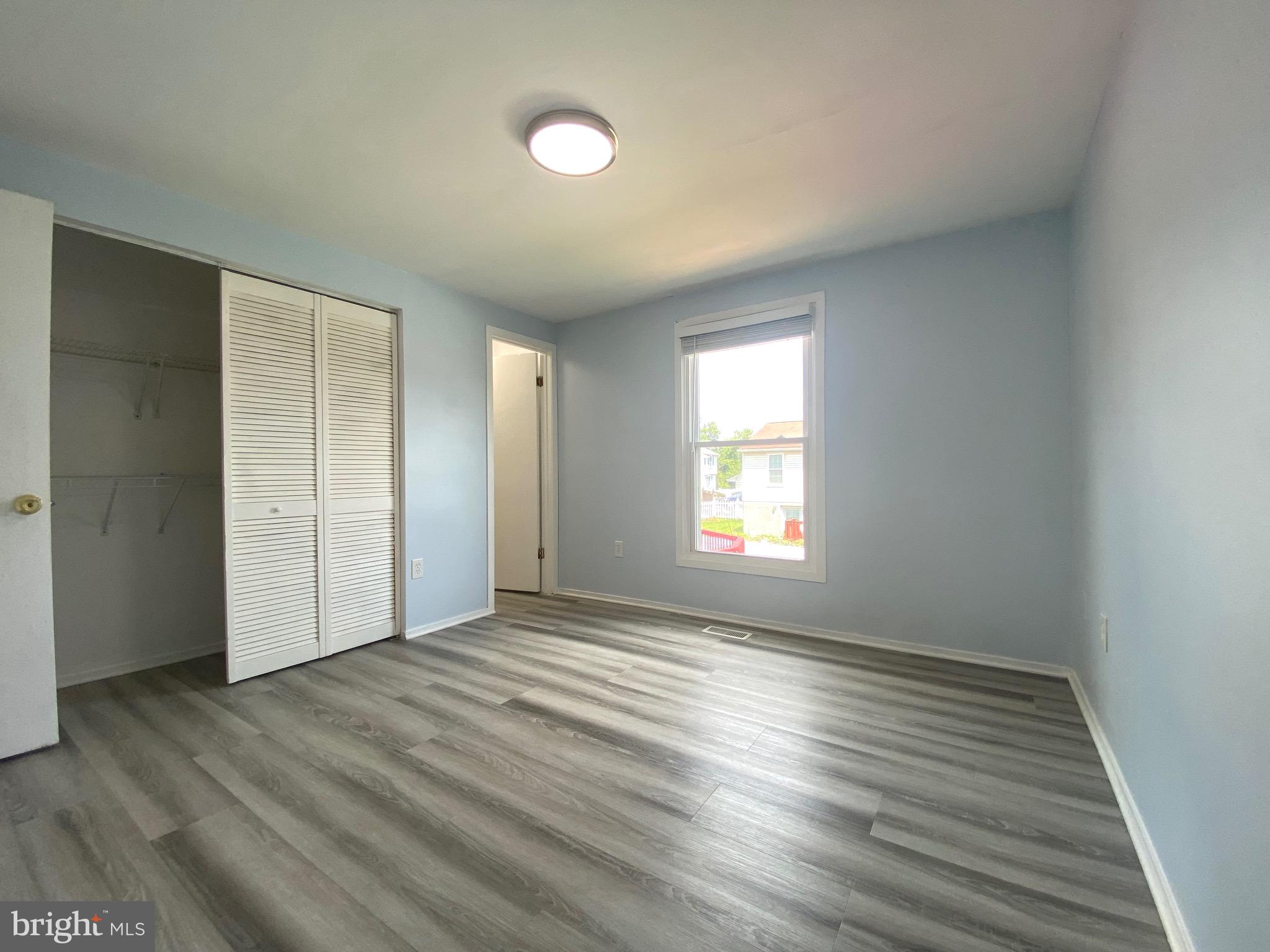 18 1st Light Court Rosedale, MD 21237 - Photo 9 of 29 an empty room with wooden floor and windows