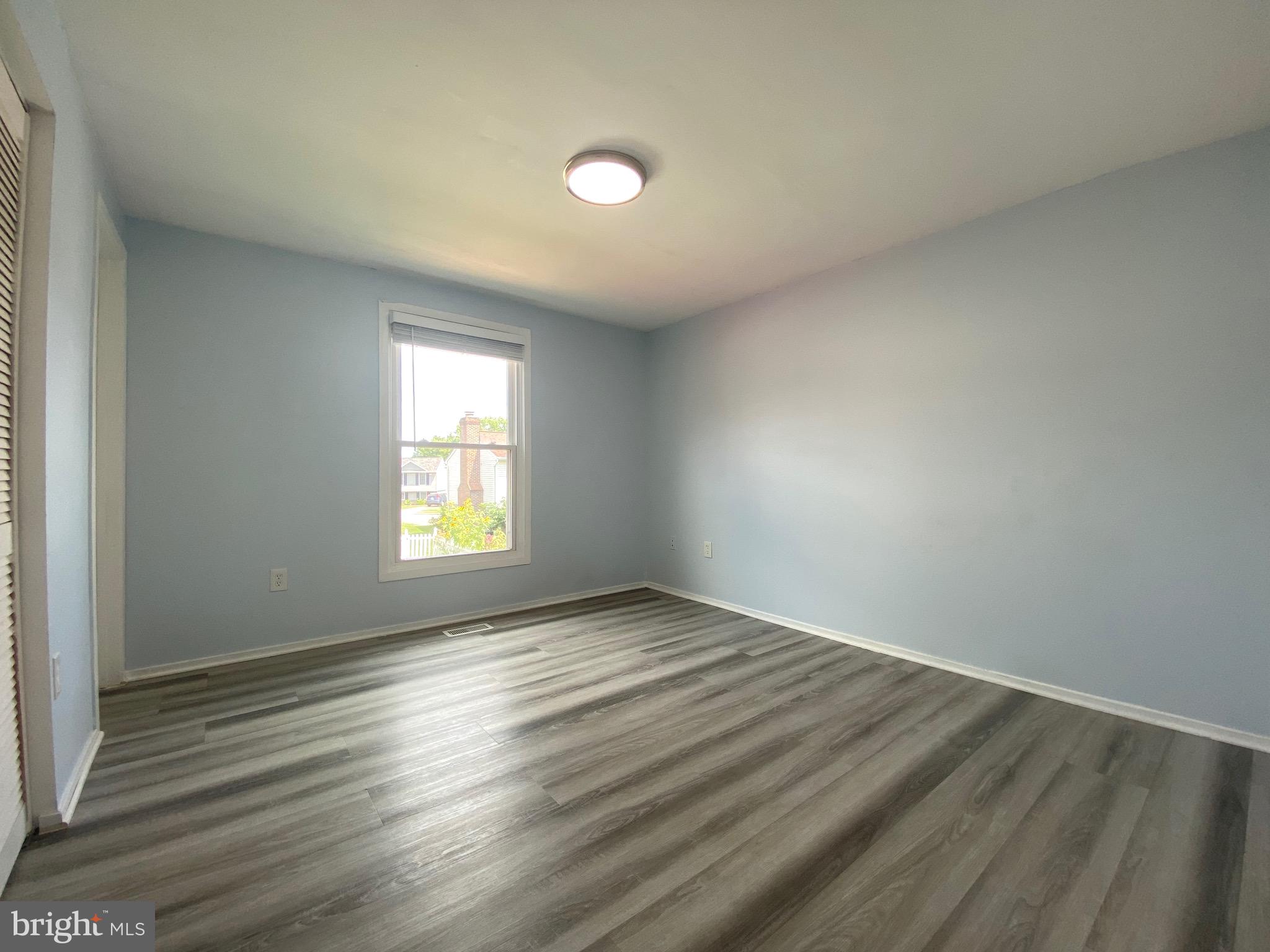 18 1st Light Court Rosedale, MD 21237 - Photo 10 of 29 an empty room with wooden floor and windows
