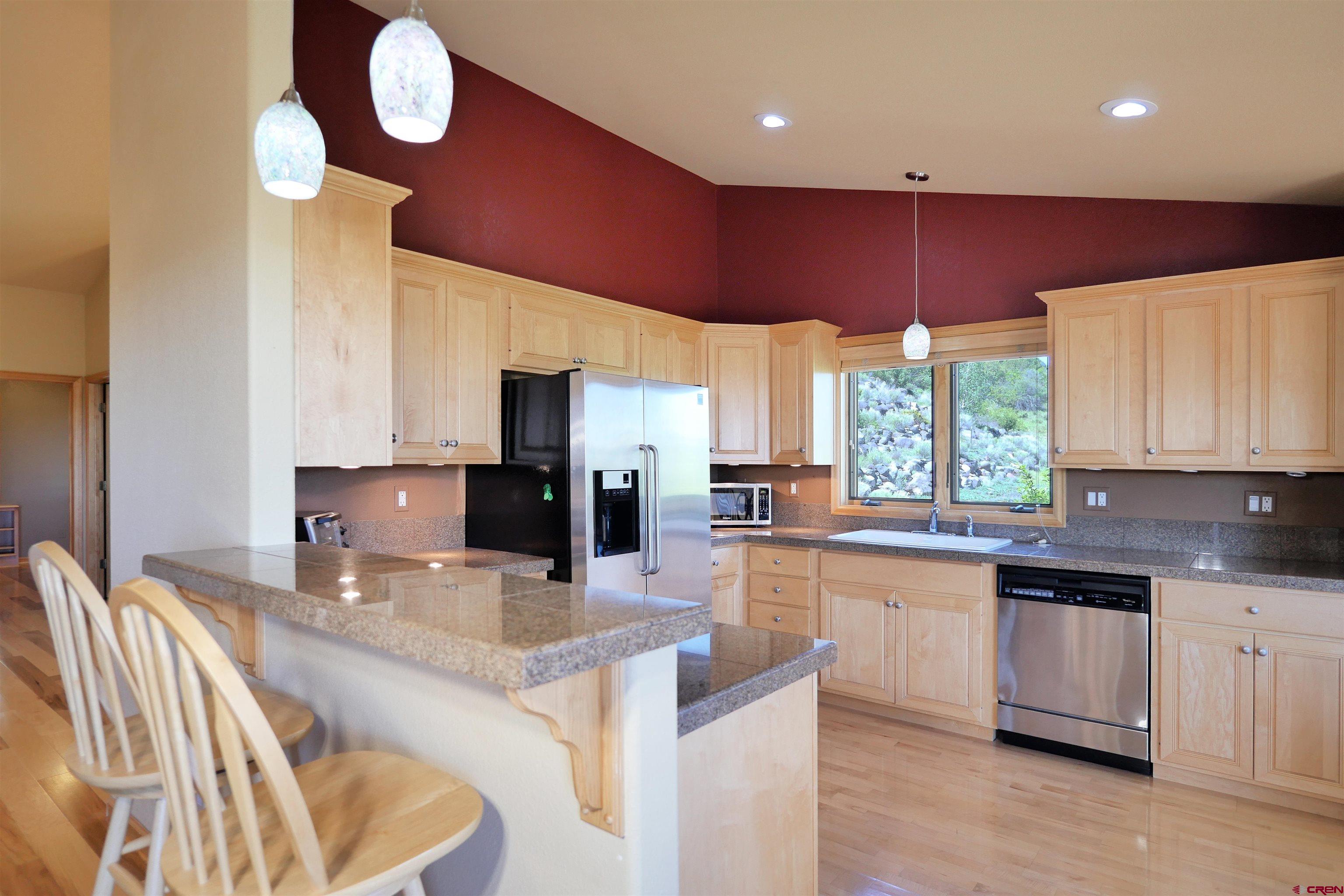 201 Woodchuck Place Ridgway, CO 81432 - Photo 14 of 33 a kitchen with stainless steel appliances kitchen island granite countertop a sink and cabinets