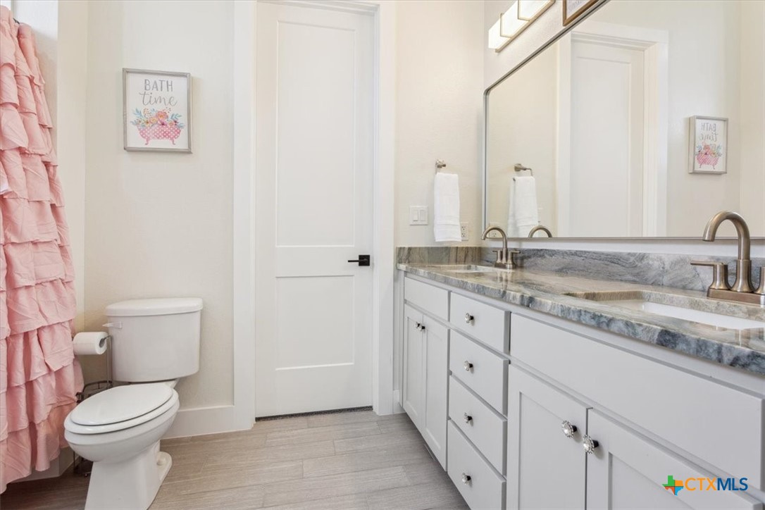 4802 Elf Trail Belton, TX 76513 - Photo 28 of 48 a bathroom with a granite countertop sink toilet and a mirror