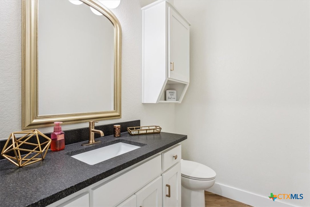 4802 Elf Trail Belton, TX 76513 - Photo 34 of 48 a bathroom with a granite countertop sink and a mirror