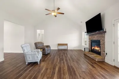 a kitchen with stainless steel appliances granite countertop wooden cabinets a stove a sink and dishwasher with wooden floor