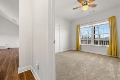 a view of an empty room with a ceiling fan