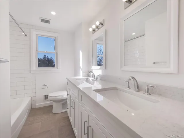 a bathroom with a double vanity sink toilet and shower