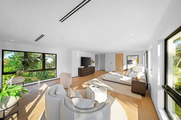 a bedroom with furniture and a large window