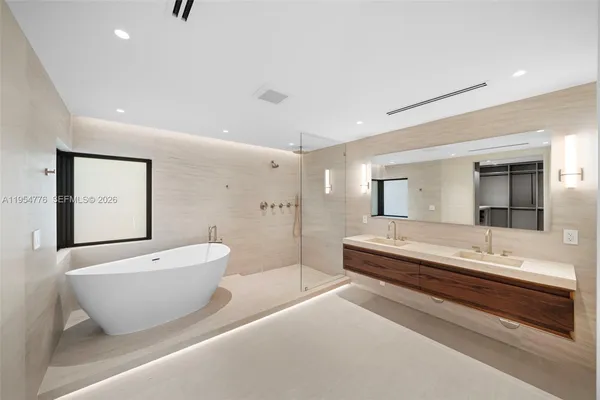 a spacious bathroom with a double vanity sink a mirror and a bathtub