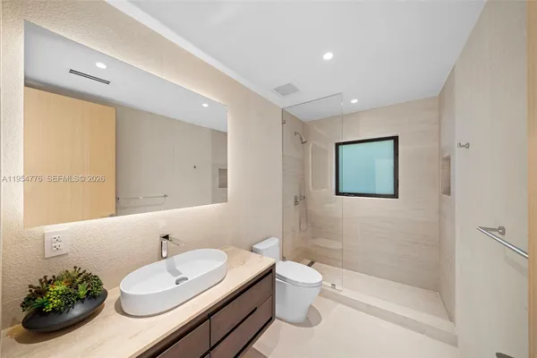 a bathroom with a sink a toilet and shower