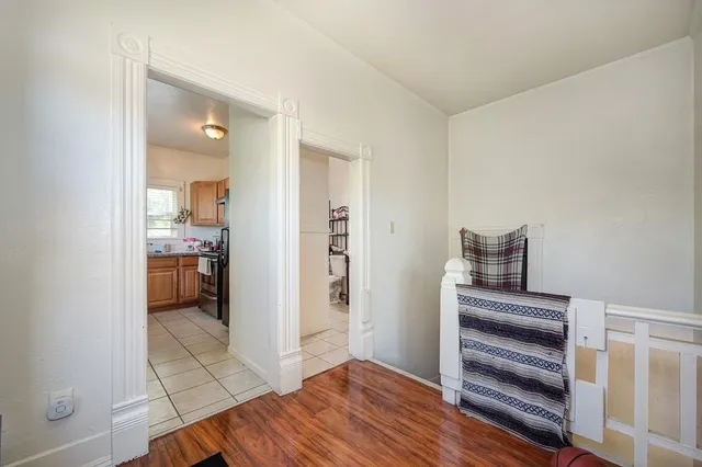a bedroom with two beds and wooden floor