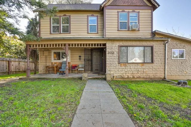 a kitchen with granite countertop a stove a sink dishwasher and white cabinets with wooden floor