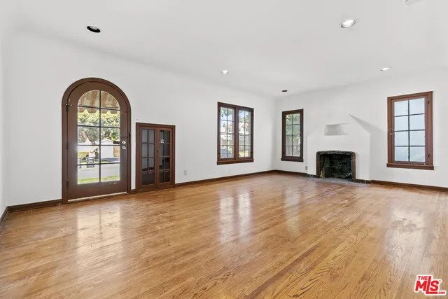an empty room with wooden floor and fireplace