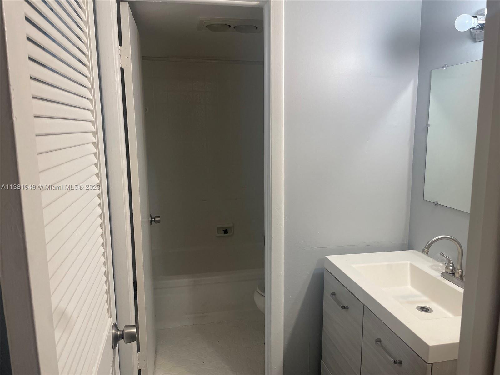 3285 Foxcroft Road, Unit E204 Miramar, FL 33025 - Photo 8 of 12 a bathroom with a sink and mirror with toilet