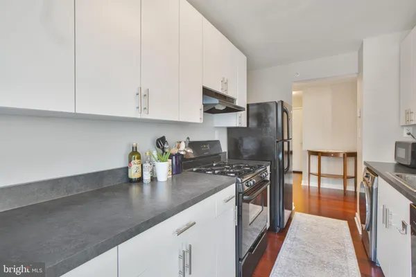 a kitchen with stainless steel appliances granite countertop a sink and a refrigerator