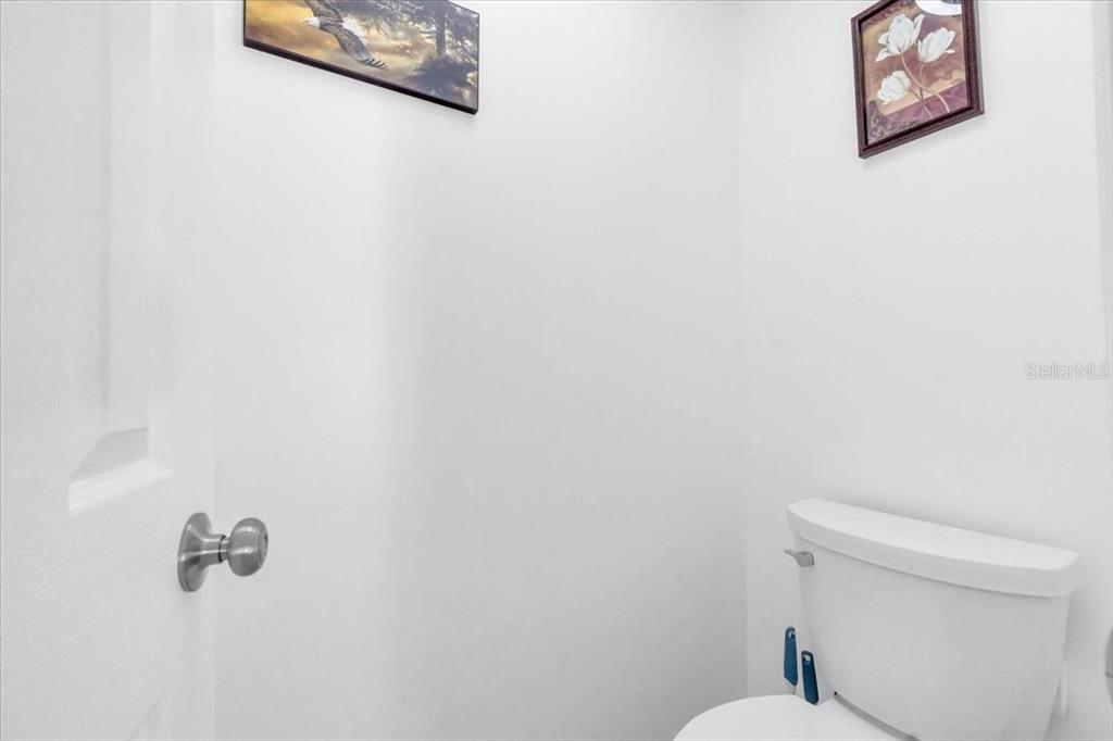 2211 Englewood Road Englewood, FL 34223 - Photo 25 of 86 a white toilet sitting next to a white wall