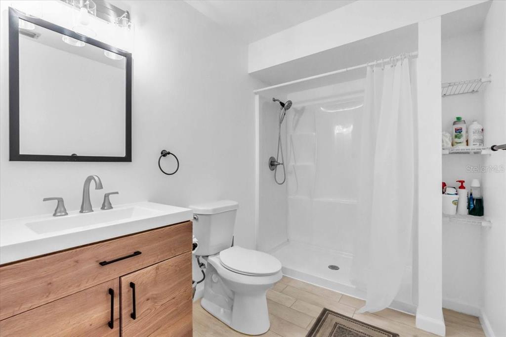 2211 Englewood Road Englewood, FL 34223 - Photo 30 of 86 a bathroom with a sink a toilet and shower