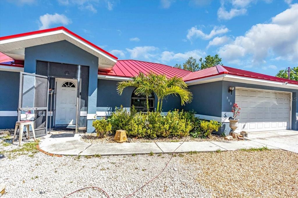 2211 Englewood Road Englewood, FL 34223 - Photo 42 of 86 a front view of a house with a yard