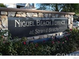 34026 Selva Road, Unit 68 Dana Point, CA 92629 - Photo 1 of 16 a sign broad in front of the red brick house