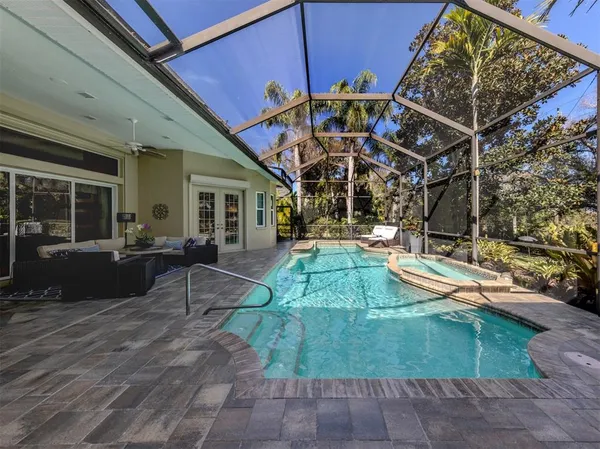 a view of a swimming pool with a lawn chair and palm trees