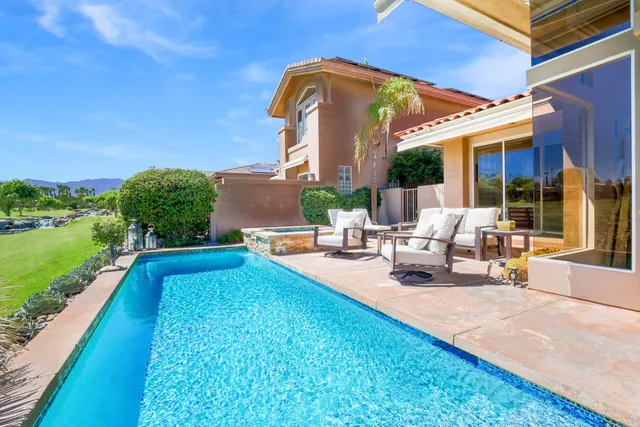 a view of a house with swimming pool and sitting area