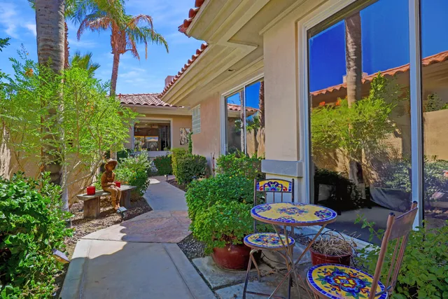 a view of a patio with table and chairs potted plants