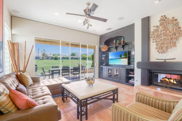 a living room with furniture and a floor to ceiling window