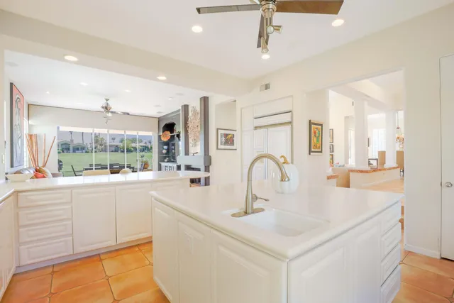 a kitchen with kitchen island a sink and a large window
