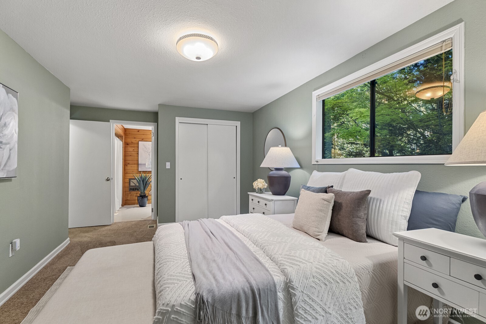 7727 Lake Alice Road Southeast Fall City, WA 98024 - Photo 12 of 34 a bedroom with a large bed and a large window